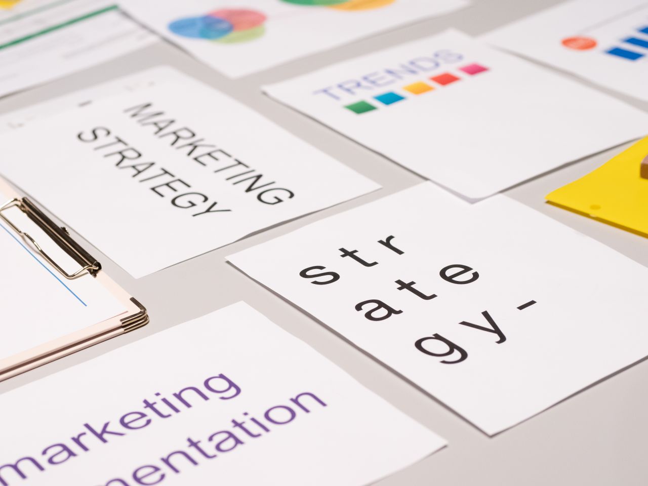 Une vue plongeante sur des documents et graphiques de stratégie marketing disposés sur un bureau, illustrant la planification d’entreprise.